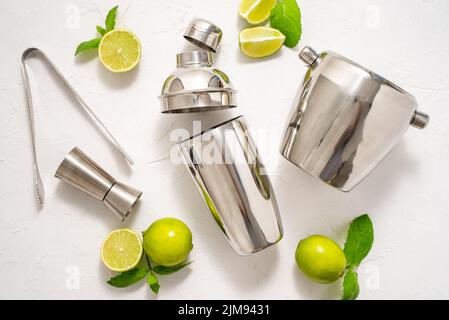 Draufsicht auf Barkeeper Coctail Tools Set. Stahlschüttler, messen, Zange mit Kalk Stockfoto