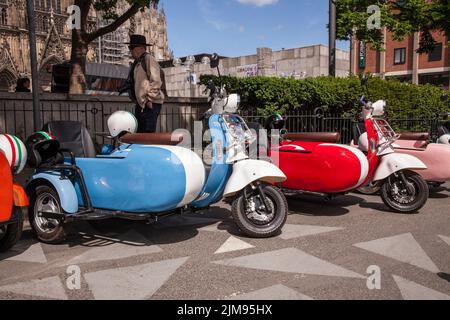 E-Vespina Roller mit Seitenwagen können für Stadtrundfahrten in der Nähe des Kölner Doms gemietet werden. E-Vespina Roller mit Seitenwagen stehen z Stockfoto