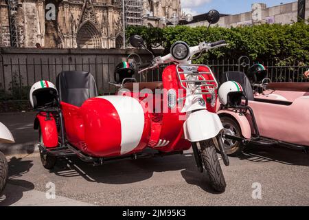 E-Vespina Roller mit Seitenwagen können für Stadtrundfahrten in der Nähe des Kölner Doms gemietet werden. E-Vespina Roller mit Seitenwagen stehen z Stockfoto