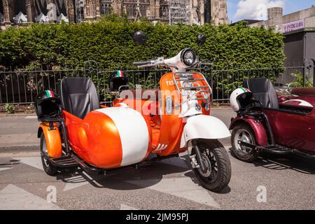 E-Vespina Roller mit Seitenwagen können für Stadtrundfahrten in der Nähe des Kölner Doms gemietet werden. E-Vespina Roller mit Seitenwagen stehen z Stockfoto