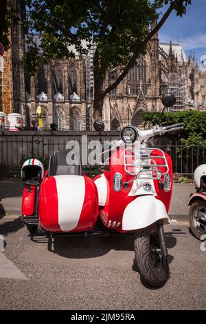 E-Vespina Roller mit Seitenwagen können für Stadtrundfahrten in der Nähe des Kölner Doms gemietet werden. E-Vespina Roller mit Seitenwagen stehen z Stockfoto