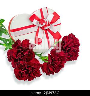 Geschenkbox in Form von Herz und Blumenstrauß von Nelken. Stockfoto