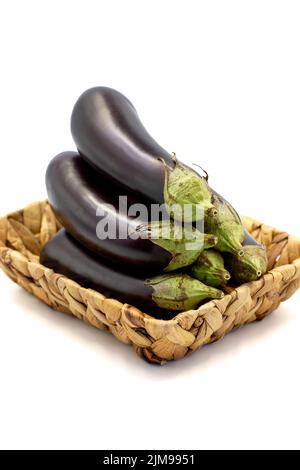 Reife Aubergine. Frische Auberginen im Korb isoliert auf weißem Hintergrund. Bio-Lebensmittel. Nahaufnahme Stockfoto