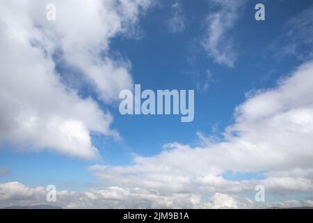 Weiße Wolken an einem klaren blauen Himmel Stockfoto