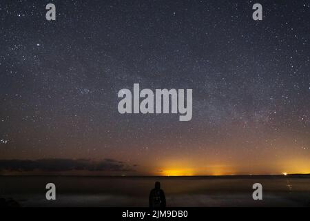 Männersilhouette unter dem Nachthimmel Stockfoto