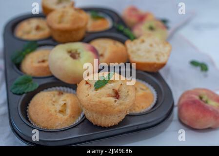 Süße hausgemachte Vanillepfirsich-Muffins auf einem Tisch Stockfoto