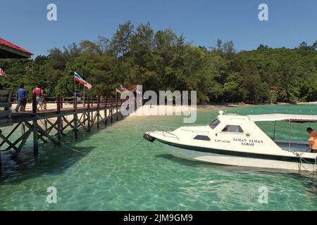 Ein Touristenboot auf dem Küstenwasser von Pulau Sapi (Sapi Insel), einem Teil des Tunku Abdul Rahman Parks in Sabah, Malaysia. Stockfoto