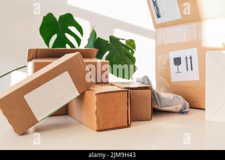 Die Ansicht von oben und die Nahaufnahme von Stapelboxen in verschiedenen Größen von klein bis groß zeigen eine schöne Beleuchtung. Sie befinden sich auf dem weißen Schreibtisch von Online-Merchan Stockfoto