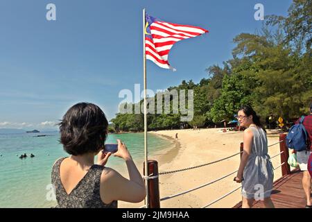 Besucher, die eine Fotosession machen, stehen auf einem Steg auf Pulau Sapi (Sapi Island), einem Teil des Tunku Abdul Rahman Parks in Sabah, Malaysia. Stockfoto