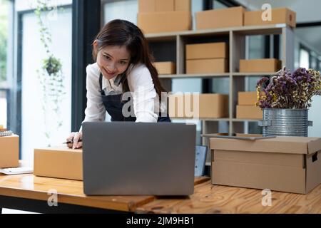 Beschäftigte junge Geschäftsfrau, die im Online-Geschäft arbeitet. Die Besitzerin des kleinen Unternehmens an ihrem Schreibtisch. Stockfoto