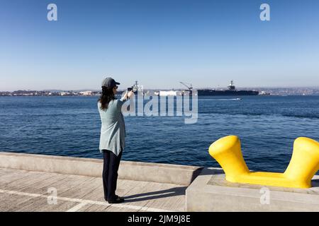 Frau, die an einem schönen Tag Fotos von der Bucht von San Diego beim Spaziergang auf dem Pier gemacht hat Stockfoto