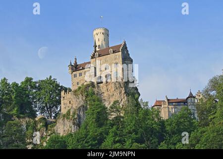 Schloss Lichtenstein in Württemberg, Deutschland. Bild mit dem Mond im Hintergrund. Stockfoto