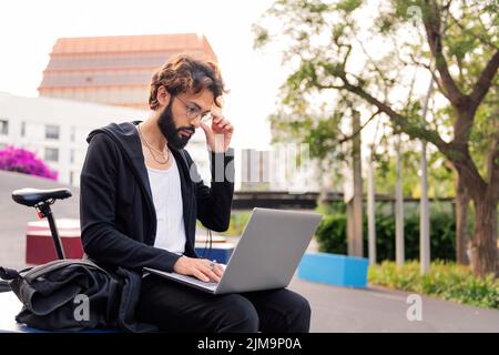 Student, der auf dem Universitätscampus mit seinem Laptop studiert, Technik- und Bildungskonzept, Platz für Text kopieren Stockfoto