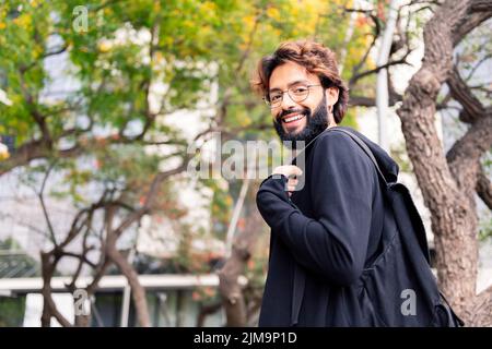 Junge Studenten mit Rucksack lächelnd glücklich im Park des Universitätscampus, Konzept der Jugend und Bildung, Platz für Text kopieren Stockfoto