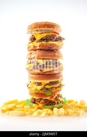 Gourmet-Burger mit Brioche-Donut, die übereinander gestapelt werden, werden mit knuffelten Pommes frites aus französischer Kartoffel serviert. Stockfoto