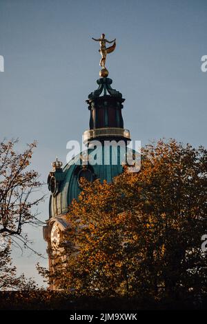 Eine vertikale Aufnahme eines Schlosses Charlottenburg mit Bäumen im Vordergrund, Berlin, Deutschland Stockfoto