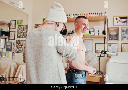 Mädchen Tätowierungen Künstler bereitet einen Ort für Tattoo auf der hand des Menschen. Stockfoto