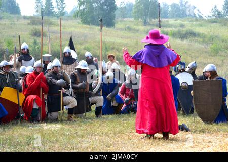 Samara, Russland, das Fest der historischen Rekonstruktion altes Russland Alter 11-13 - 16. August 2013 - : Mann in einem Kleid des 13.. Jahrhunderts katholischen Priesters mit einem rosa Gewand, lila Hut segnet mittelalterlichen Krieger in die Schlacht Stockfoto