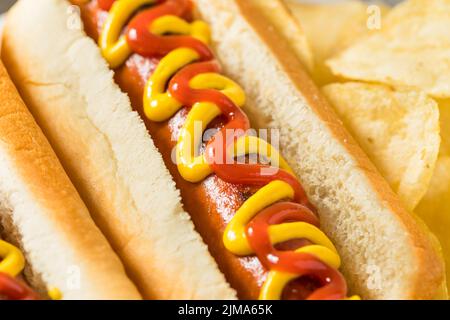Hausgemachter Hot Dog mit Ketchup und Senf mit Kartoffelchips Stockfoto