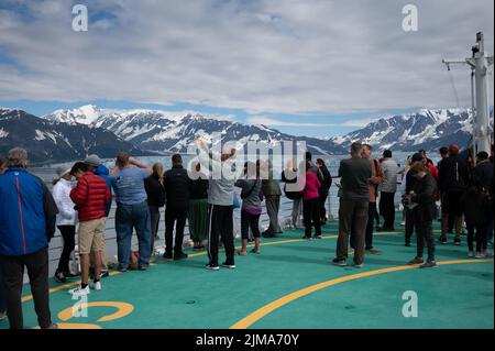 Hubbard-Gletscher, Alaska - Juli 28. 2022: Touristen an Bord der Serenade Seas beobachten, wie das Schiff durch die Yakutat Bay in Richtung Hubbard Glace fährt Stockfoto