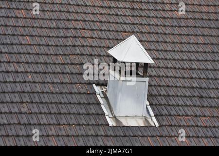 Metallkamin auf schwarzem Ziegeldach Stockfoto