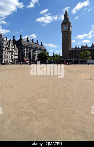 London, Großbritannien. 5. August 2022. Menschen auf braunem Rasen auf dem Parliament Square gegenüber dem Parlamentsgebäude. Sonne im West End, während die Hitzewelle anhält. Kredit: JOHNNY ARMSTEAD/Alamy Live Nachrichten Stockfoto