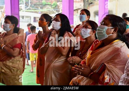 Howrah, Westbengalen, Indien - 14.. Oktober 2021 : Hindu-Anhänger, die der Göttin Durga Pushpanjali anbieten, ein Ritual, um die Göttin mit Blumen zu verehren. Stockfoto