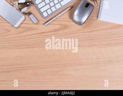 Holztischplatte mit Büroausstattung und Zubehör am oberen Bildrand Stockfoto