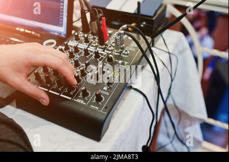 Hand des Mannes auf digitalen Mischpult. Sound-Mixer-Systemsteuerung, Nahaufnahme von audio Fader. Stockfoto