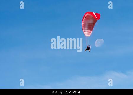 Fliegen mit dem Paramotor in der Luft auf blauem Himmel Hintergrund. Stockfoto