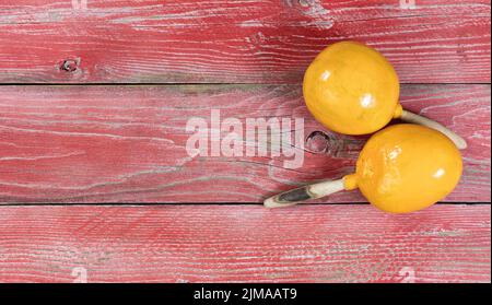 Traditionelle Maracas für die Weihnachtsfeier des Cinco de Mayo auf roten rustikalen Holzbrettern Stockfoto