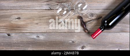 Öffnen Sie eine Flasche Rotwein und saubere Trinkgläser auf rustikalen Holzbrettern Stockfoto