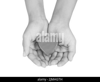 Herzpflege, medizinisches Konzept. Herz in den Händen eines Kindes. Schwarzweiß-Bild Stockfoto