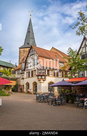 Outdoor-Gastronomie auf einem kleinen Platz in eberbach in süddeutschland. Fachwerkhäuser und eine Kirche im Hintergrund Stockfoto