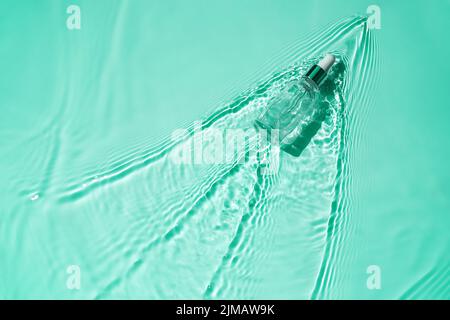 Feuchtigkeitsspendendes Serum mit Hyaluronsäure in der Flasche mit Pipette auf Wasser Stockfoto