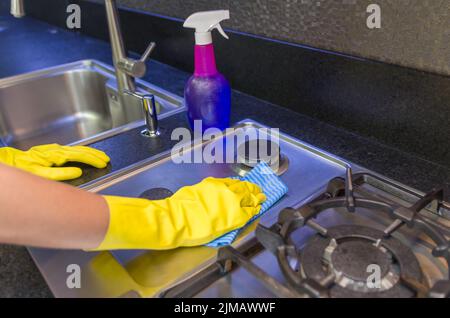 Tolles Konzept der häuslichen Reinigung, Frau Reinigung der Spüle Stockfoto