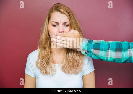 Tolles Konzept der männlichen Zensur, die Frau mit dem Mund durch die Hand des Menschen fallen. Stockfoto