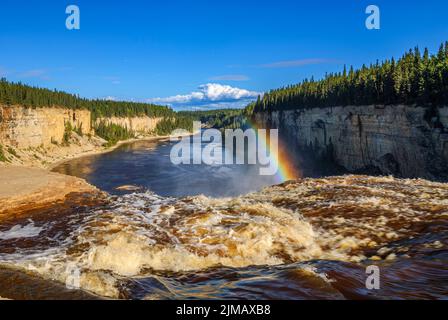 Im Spray bildet sich ein Regenbogen, während der Hay River über den Rand der Alexandra Falls im Twin Falls Gorge Territorial Park, Northwest Territories, stürzt Stockfoto
