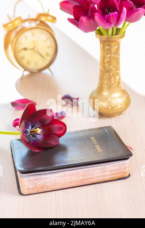 Heilige Bibel mit Blumen auf hölzernen Tisch Stockfoto