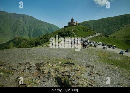 Stepantsminda, Georgia, zeigt Gergeti Trinity Church , Tsminda Sameba oder Holy Trinity Church, in der Nähe des Dorfes Gergeti Außenansicht bei Tageslicht. Stockfoto