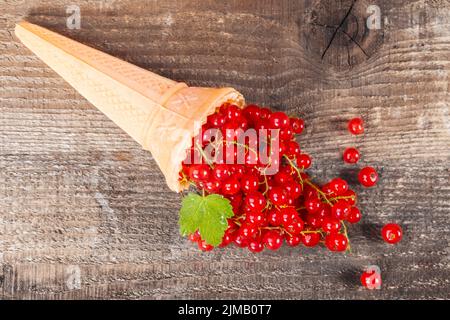 Rote Johannisbeere Früchte in Eis auf hölzernen Tisch Stockfoto