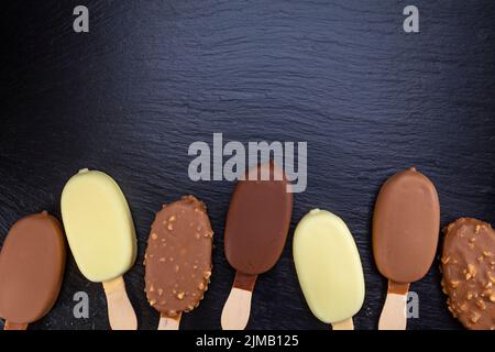 Eis auf Stick mit Schokolade auf schwarz bedeckt Stockfoto