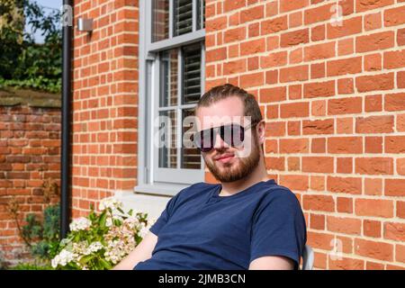 Eine flache Fokusaufnahme eines kaukasischen Mannes, der charmant lächelt Stockfoto