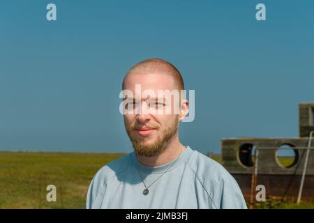 Eine flache Fokusaufnahme eines kaukasischen Mannes, der charmant lächelt Stockfoto