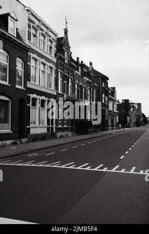 Eine Graustufenaufnahme einer typischen Straße mit kleinen Stadthäusern in Venlo, Niederlande. Stockfoto