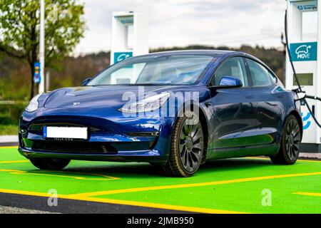 Ein blaues Tesla-Auto an der Ladestation Stockfoto