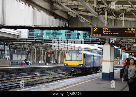 Eine Aufnahme eines Northern Trains 'Pacer' und Fahrgäste auf einem Bahnsteig auf einem Bahnhof in Sheffield, South Yorkshire, England Stockfoto