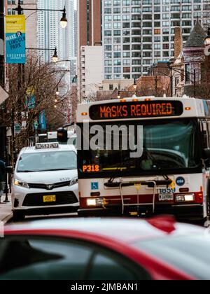 Eine vertikale Aufnahme eines Busses mit einer Maske erforderte ein Schild in Chicago, USA Stockfoto