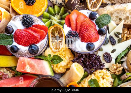 Eine Nahaufnahme von verschiedenen Früchten, Käse, Brot und Dessert auf einer Platte Stockfoto