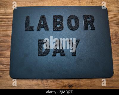 Die Worte Labor Day in schwarzen Buchstaben auf einem schwarzen Hintergrund. Perfekt für fröhliche Beiträge zum Labor Day in den sozialen Medien. Stockfoto